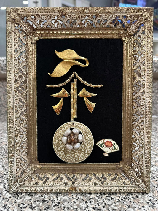 Art piece made of vintage jewelry on velvet, in an old decorative frame