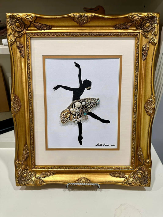 artwork of the silouette of a ballerina made from vintage jewelry on a white background in a golden frame