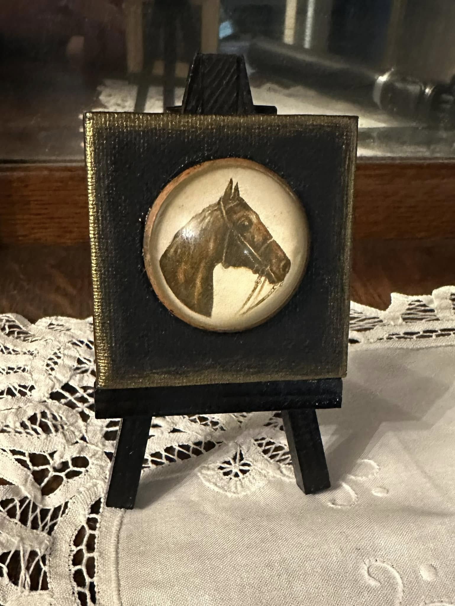 This exquisite horse brooch features intricate detailing on a 2.5" x 2.5" canvas, showcasing original artwork as its backdrop, and . presented on a mini-easel. It stands about 5" tall and is the perfect little piece of mini-art to bring color, beauty, fun, and joy to any space- an end table, kitchen or bathroom counter, shelf decor, work space, etc. It's a nice affordable gift for yourself, a family member, a friend, or coworker.